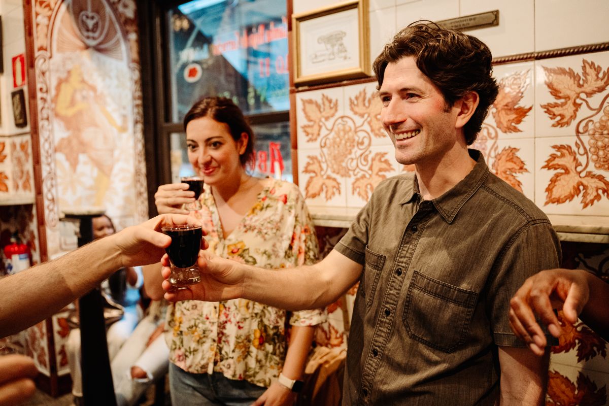 A woman and man enjoying small glasses of wine or vermouth at a taberna in Madrid