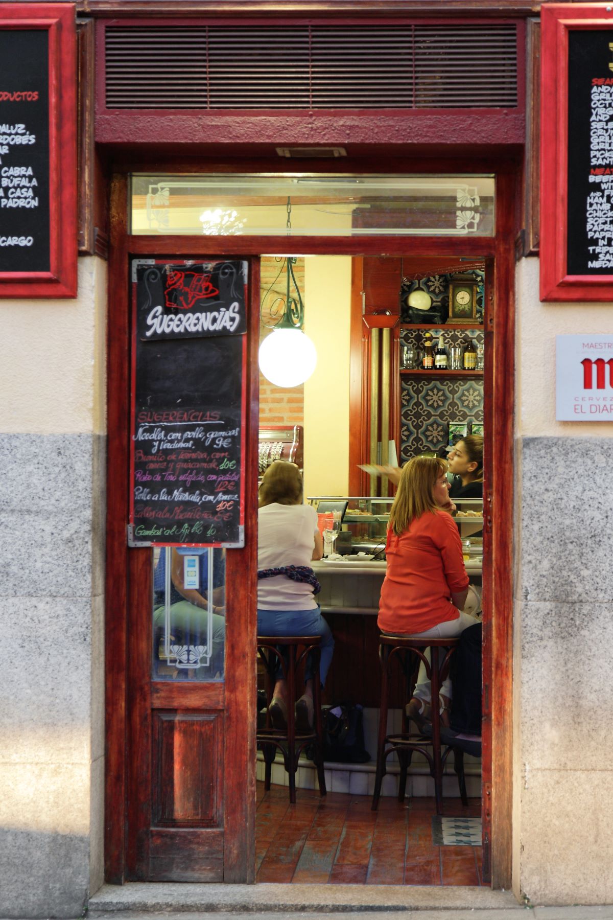 A woman sitting at the bar eating lunch at El Diario during lunch time in Madrid.
